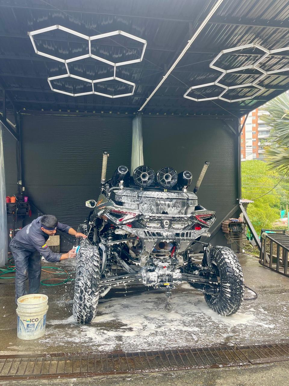 Miembro del equipo lavando a detalle las ruedas de una cuatrimoto